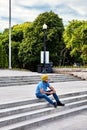 Young indian sikh sitting on the stairs of mount royal park and talking on the phone with his earphones in Montreal, Canada