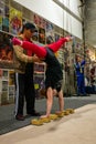 MONTREAL, CANADA - Oct 19, 2012: White, Blond, Strong Woman is Standing on her Hands and the Help of her Coach