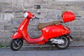 Montreal, Canada - October 27, 2019 - A bright red Vespa scooter parked on the brick street