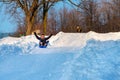 Sledding down snow covered hill with hands in the air