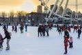 Montreal tourism - winter skating rink near the Ferris wheel. People are skating in the winter against the background