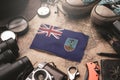 Montserrat Flag Between Traveler`s Accessories on Old Vintage Map. Tourist Destination Concept