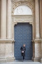 Montserrat, Spain - April 5, 2019: Young wonan poses in front of the Santa Maria de Montserrat Abbey, Catalonia, Spain.