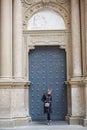 Montserrat, Spain - April 5, 2019: Young wonan poses in front of the Santa Maria de Montserrat Abbey, Catalonia, Spain.