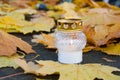 Monument and candles in the cemetery. All Saints Day in Poland. Candle in the cemetery. Candle in the yellow leaves. Royalty Free Stock Photo