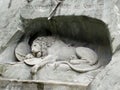 Monument `The Dying Lion` in Lucerne. Switzerland. High relief carved in a steep rock behind an oval pond.