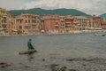 Monument Il Pescatore of the Leonardo Lustig in the bay of the Silence in Sestri Levante, Liguria, Italy across the colorful house