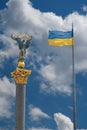 Monument of Independence in Kiev and ukrainian flag against blue sky with white clouds Royalty Free Stock Photo