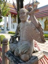 Monument of a man with a ball on his palm and a dragon at the feet of gray stone.