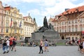 Monument on the square of old Prague surrounded by tourists.