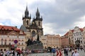 Monument on the square of old Prague surrounded by tourists.