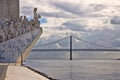 Monument to the Discoveries Padrao dos Descobrimentos at the Tagus river with view on 25th of April Bridge Lisbon - Portugal Royalty Free Stock Photo