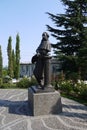 Monument to a man of the 18-19th centuries on the square in front of the building, surrounded by flowering flower beds Royalty Free Stock Photo