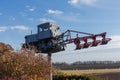 Monument to old caterpillar tractor with mounted plough against field