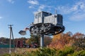 Monument to old caterpillar tractor with plough against modern tractor