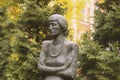 Monument to the Russian poetess Anna Akhmatova against the background of autumn branches of thuja