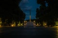 Monument to the Unknown Soldier with eternal fire in the evening. The tiled road in the night green park with lanterns. Royalty Free Stock Photo