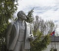 Monument to Lenin on the background of the tree and the flag of Russia