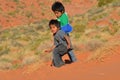 Unidentified navajo children playing in the sand of monument valley