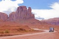 The Monument Valley in UtahÃ¢â¬âArizona state with the red earth desert, winding country road and Pick-up truck