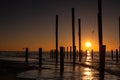 Monumental wooden poles, including a swing set, in the sea during a lovely sunset in the Netherlands Royalty Free Stock Photo