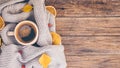 Autumn or Fall composition. Fall leaves, orange chips, hot steaming cup of coffee and a cozy grey sweater on wooden Royalty Free Stock Photo