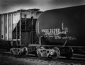 Black and white image of train cars sitting idle in a train yard