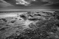 Moody black and white sunset on the beach at low tide. Royalty Free Stock Photo