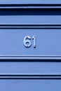 House number 61 with horizontal lines in blue