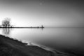 Moody calm shoreline with still waters reflecting in early morning light.