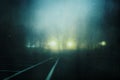 A moody concept of a car park with street lights on a foggy night in a city. With a grunge, artistic, edit