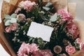 Moody feminine wedding, birthday mockup scene. Closeup of blank cotton paper card, invitation on pink floral bouquet Royalty Free Stock Photo