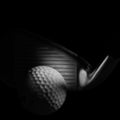 Moody golf club head and ball on a black background. Royalty Free Stock Photo