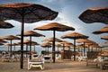 moody image hotel beach area with umbrellas and sun loungers cloudy weather, horizontal