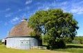 Moody Lake Barn near Chisago City, Minnesota round blue barn near a lake with trees and a fence in summer.