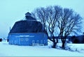 Moody Lake Barn near Chisago City, Minnesota round blue barn near a lake with trees and a fence in Winter