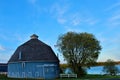 Moody Lake Barn near Chisago City, Minnesota round blue barn near a lake with trees and a fence in Spring