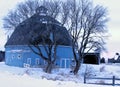 Moody Lake Barn near Chisago City, Minnesota round blue barn near a lake with trees and a fence in Winter