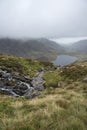 Landscape image of Llyn Idwal in Glyders mountain range in Snowdonia during heavy rainfall in Autumn