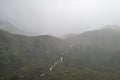 Moody landscape image of low cloud hanging over Snowdonia mountain range after heavy rainfall in Autumn with misty weather Royalty Free Stock Photo