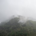 Moody landscape image of low cloud hanging over Snowdonia mountain range after heavy rainfall in Autumn with misty weather Royalty Free Stock Photo