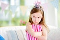 Moody little girl wearing princess tiara feeling angry and unsatisfied