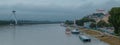 Moody panorama of Bratislava city viewed from the bridge looking towards castle and Novy bridge over the river on a dull grey day