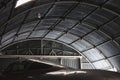 Moody shot of a fighter jet aircraft in a big aviation hangar