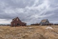 A moody sky over two abandoned homes on the prairies of Saskatchewan