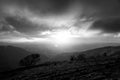 Moody sunset on Monte Cucco Umbria, Italy, with tree in the foreground and sun filtering through clouds Royalty Free Stock Photo