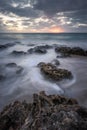 Moody sunset over water movements on beach rocks in Kenting, Taiwan