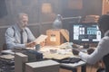 Moody two police detectives studying case in retro styled office