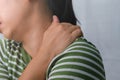 Moody young woman holding her neck. Tired woman massaging stiff neck, straining muscles, exhausted from work. Upper arm pain. Royalty Free Stock Photo