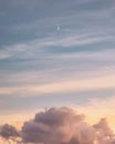 The moon above the clouds at sunset